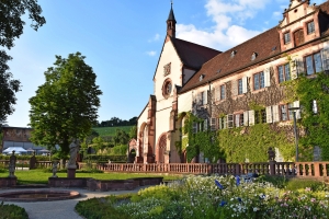 Garten mit historischen Gebäuden und blühenden Pflanzen im Kloster Bronnbach.