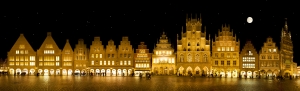 Beleuchtete historische Gebäude bei Nacht mit Sternenhimmel und Vollmond.