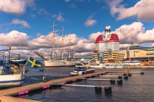 Schiff im Hafen von Göteborg vor dem Utkiken-Gebäude und blauem Himmel.