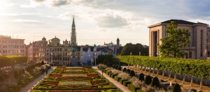 Städtische Parkanlage mit Blumenbeeten und historischer Architektur im Hintergrund.