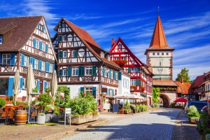 Fachwerkhäuser und ein Turm in einer malerischen Altstadt bei sonnigem Wetter.
