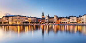 Panorama von Stockholms Altstadt bei Sonnenuntergang mit Spiegelung im Wasser.