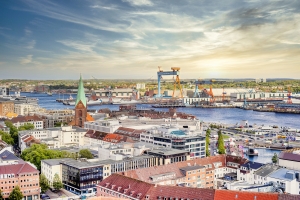 Luftaufnahme von Kiel mit Hafen und Stadtansicht bei Sonnenuntergang.