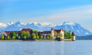 Inselstadt Lindau am Bodensee vor schneebedeckten Alpen im Frühling.