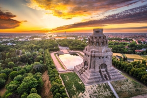 Panoramablick über Leipzig bei Sonnenuntergang mit dem Völkerschlachtdenkmal im Vordergrund.