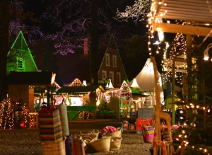 Weihnachtsmarkt mit Lichtern, Buden und beleuchteten Bäumen in Velen bei Nacht.