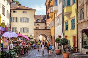 Straßenszene in einer Altstadt mit bunten Gebäuden und Fußgängern