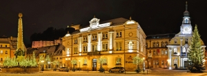 Winterliches Panorama mit beleuchtetem Rathaus in Kulmbach bei Nacht.
