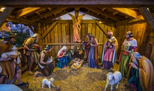 Weihnachtskrippe mit Holzfiguren, Maria, Josef und Christkind in der Mitte.
