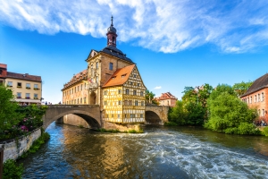 Fachwerkhaus auf Brücke über Fluss bei blauem Himmel.