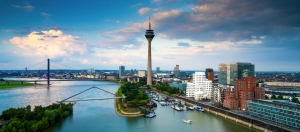 Skyline von Düsseldorf mit dem Rheinturm und den Gehry-Bauten im Medienhafen bei Sonnenuntergang.