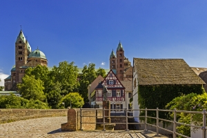 Fachwerkhaus und Dom in der Altstadt bei Sonnenschein mit blauem Himmel.