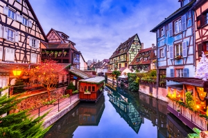 Fachwerkhäuser und Kanal in einer malerischen Stadt bei Dämmerung.