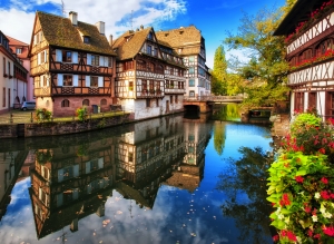 Fachwerkhäuser an einem Kanal in einer malerischen Altstadt mit Herbstlaub.