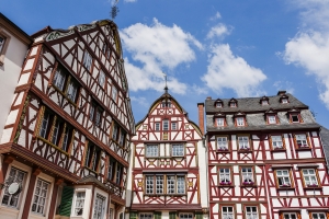 Fachwerkhäuser vor blauem Himmel mit Wolken.