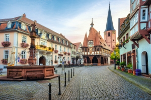 Historisches Stadtzentrum mit Fachwerkhäusern und Kirche bei Sonnenuntergang.