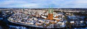Luftaufnahme einer verschneiten Stadt mit Kirchen und Fluss.