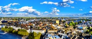 Panorama einer Stadt mit historischen Gebäuden und blauem Himmel.