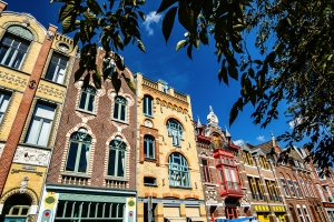 Straße mit historischen, bunten Gebäuden unter blauem Himmel.