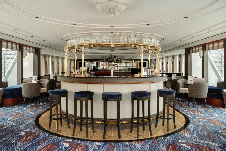 Elegante Lounge-Bar mit runder Theke, Hochstühlen und kunstvollem Teppichmuster.