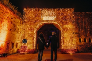 Zwei Personen vor beleuchtetem Tor im Christmas Garden Koblenz 2022.
