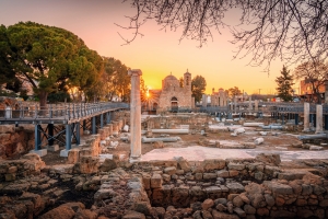 Agia Kyriaki Chrysopolitissa Kirche in Paphos bei Sonnenaufgang mit antiken Ruinen im Vordergrund.