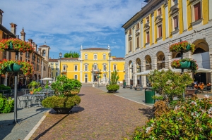 Palazzo Martinengo Palatini in Brescia mit blühenden Pflanzen und einem klaren Himmel.