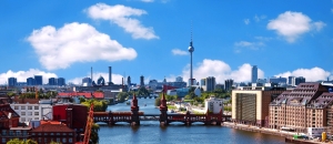 Luftaufnahme der Berliner Skyline mit der Spree, dem Fernsehturm und der Oberbaumbrücke an einem klaren Tag.