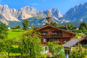 Traditionelles Almhaus in Going am Wilden Kaiser vor der Kulisse der Tiroler Alpen.