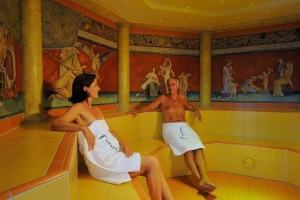 Personen im römischen Schwitzbad der Johannesbad Therme, Wandmalereien im Hintergrund.