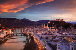 Stadtansicht von Salzburg bei Sonnenuntergang mit Festung Hohensalzburg im Hintergrund.