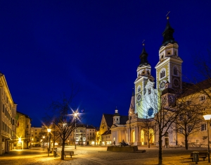 Nachtansicht des beleuchteten Brixner Doms im Winter auf dem Domplatz in Brixen, Trentino-Südtirol.