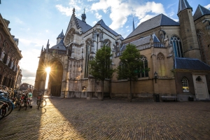 Eine historische Kirche mit Bäumen im Vordergrund bei Sonnenuntergang.