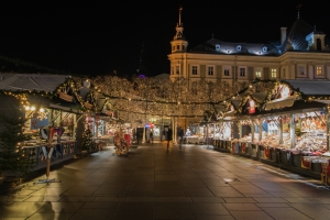 Beleuchteter Weihnachtsmarkt bei Nacht mit geschmückten Ständen und Lichtern.