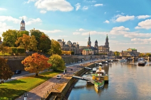 Blick auf Dresden mit Elbe, historischer Architektur und Herbstbäumen.