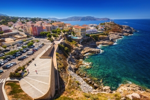 Küste und Hafenstadt in Calvi, Korsika, Frankreich mit bunten Gebäuden und klarem blauen Meer.