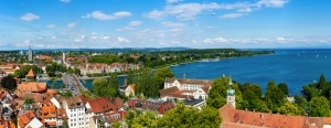 Panorama von Konstanz am Bodensee, mit Blick auf die Stadt und den See unter blauem Himmel.