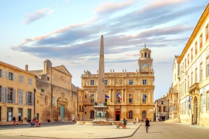 Historischer Platz mit Obelisk und alten Gebäuden bei Sonnenuntergang.