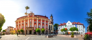 Marktplatz und historisches Rathaus von Bad Windsheim im Sonnenschein mit umliegenden Gebäuden und Bäumen.