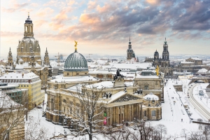 Verschneite Stadtansicht mit historischen Gebäuden bei Sonnenuntergang.