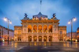 Historische Fassade der Wiener Staatsoper in Österreich bei Dämmerung mit Beleuchtung.