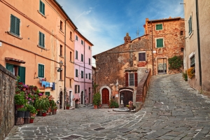 Gepflasterte Gasse mit bunten Häusern in einer ruhigen italienischen Stadt.