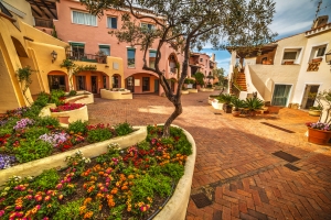 Mediterraner Innenhof mit bunten Blumen und gepflasterten Wegen.