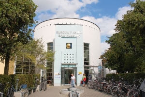 Eingangsbereich der Europa Therme Bad Füssing mit fahrradparkenden Besuchern.