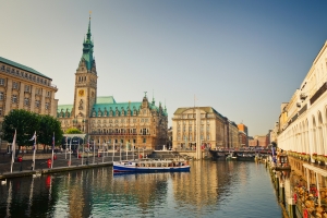Bhttps://image-archive.pressmind.io/pr03/G352/35202/3520253-3520253-V1-P0.webplick auf das historische Hamburger Rathaus und die Alsterarkaden mit einem Boot auf der Binnenalster, aufgenommen vom Jungfernstieg in Hamburg.