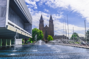Die St. Walburgiskerk in Arnheim, Gelderland, Niederlande, mit dem Fluss Rhein im Vordergrund.