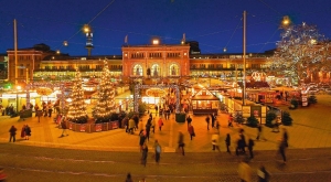 Weihnachtsmarkt am Abend mit Lichtern und Menschen bei festlicher Stimmung.