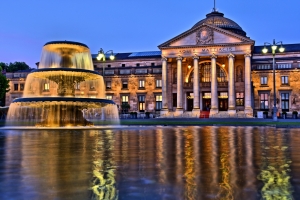Historischer Kuppelbau mit großem Springbrunnen bei Abenddämmerung.
