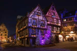 Fachwerkhäuser mit festlicher Beleuchtung in der Abenddämmerung.