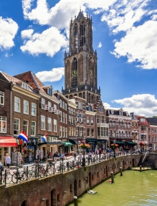 Kanal mit Altstadt und großer Kirche bei blauem Himmel.